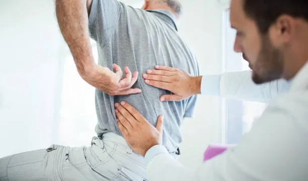 Paciente con molestias en la zona lumbar causadas por la compresión del nervio ciático, limitando su movimiento.