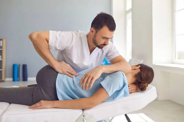 Sesión de fisioterapia donde un especialista trata el dolor de espalda baja con técnicas de manipulación y ejercicios.
