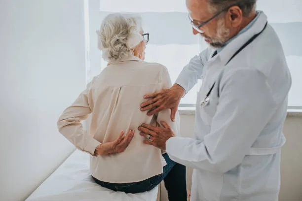 Sesión de consulta en clínica de la columna vertebral donde se evalúan lesiones musculares o articulares en la zona de la espal