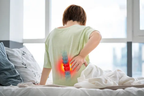 Fotografía de paciente señalando región lumbar con dolor asociado a una posible hernia de disco