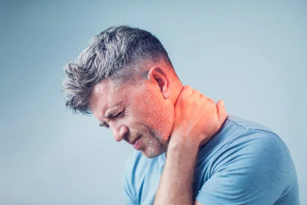Hombre sujetando su cuello con incomodidad causada por lesiones cuello, mostrando rigidez y malestar cervical que limitan su movimiento y afectan sus actividades diarias.