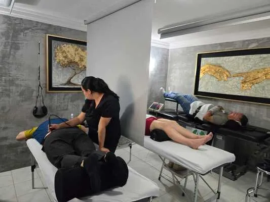 Mujer realizando terapia física a paciente en camilla para tratar hernia de disco